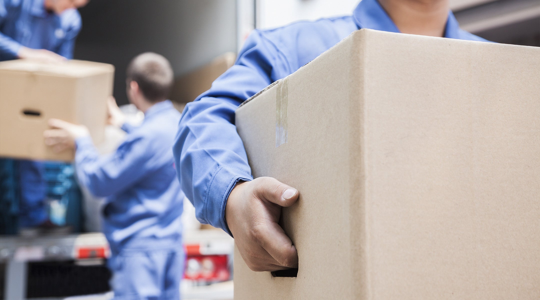 Image of a moving company worker carrying a box