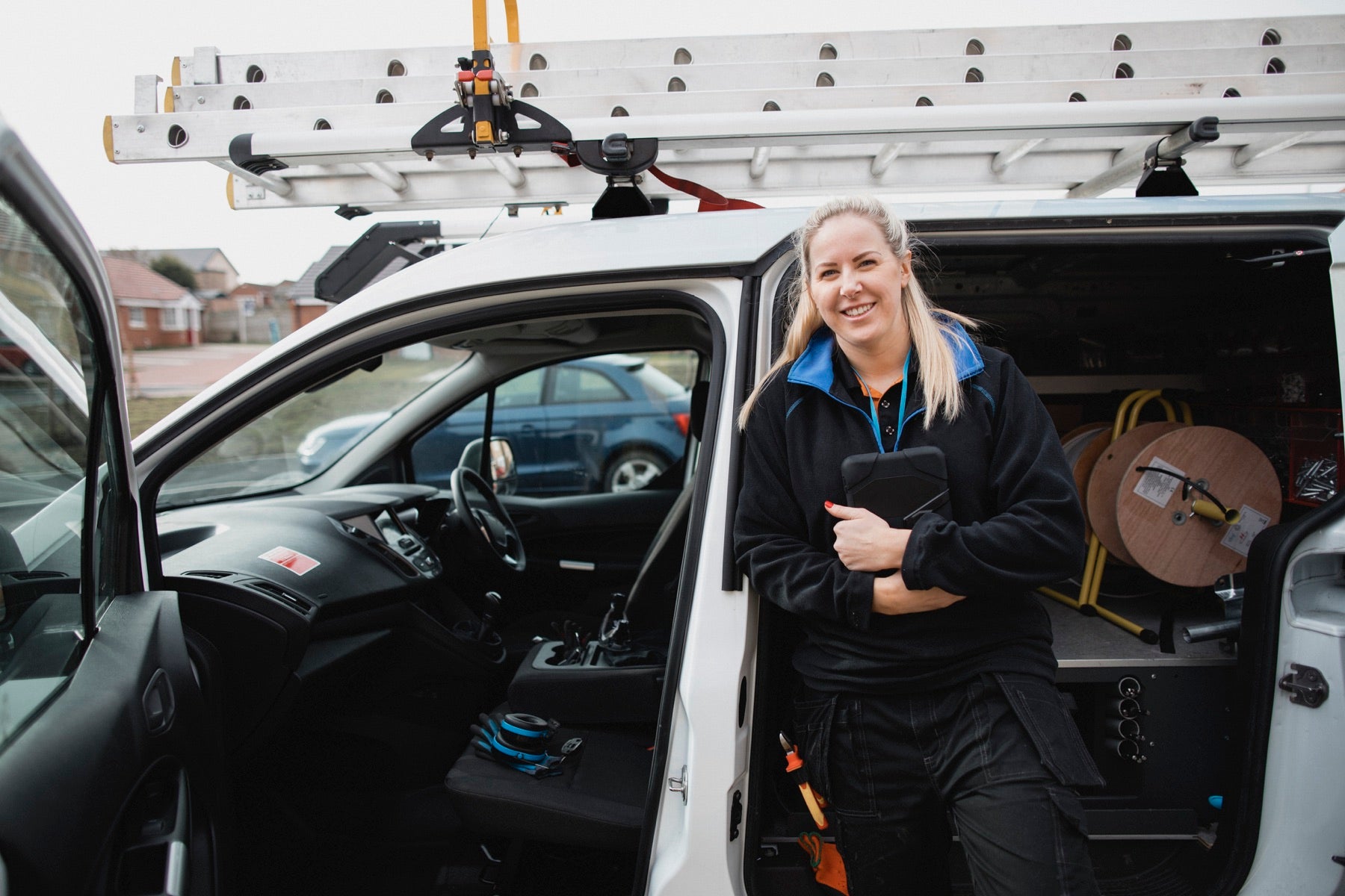 Service technician with a tablet beside a work van