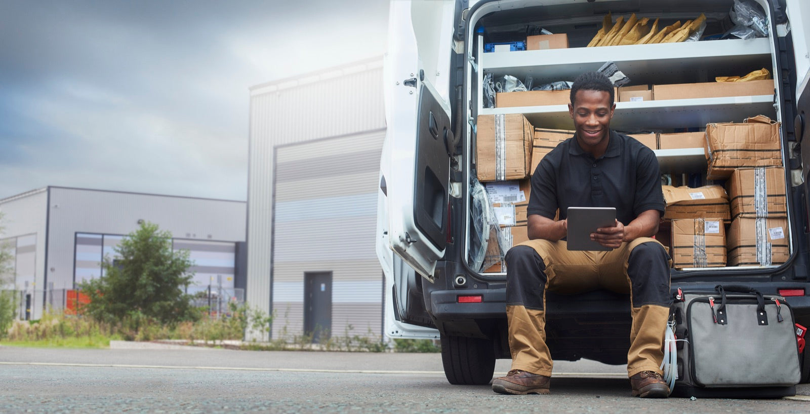 Service engineer reviewing a tablet at his work van